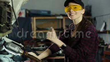 一个漂亮的黑发女孩，一个汽车维修技工，戴着帽子和格子衬衫，修理汽车`发动机和